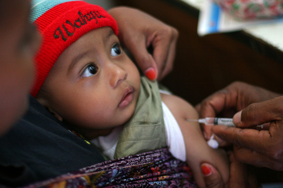 A health worker vaccinates a toddler against measles - UNICEF/Josh Estey The politics of health